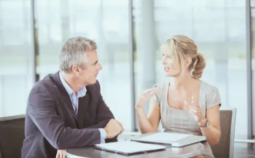 Dos personas reunidas para analizar las necesidades de una empresa